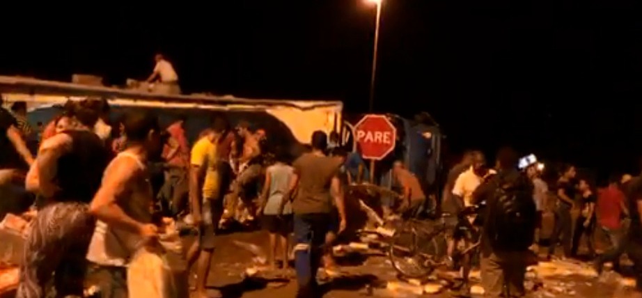 Caminhão tomba na BR-153 e população causa confusão para saquear carga