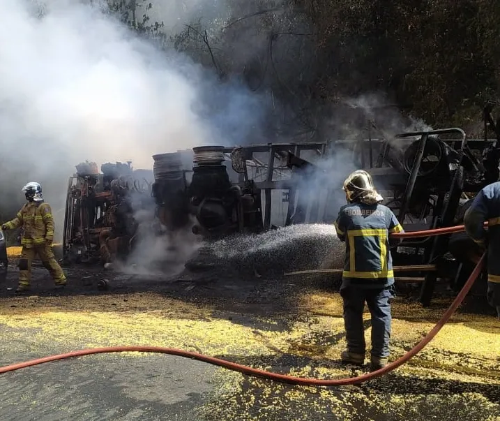 Carreta carregada com milho tomba e pega fogo na BR-153