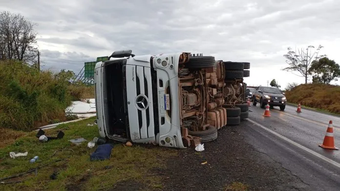 Motorista e passageira ficam feridos após carreta carregada tombar na PR-092