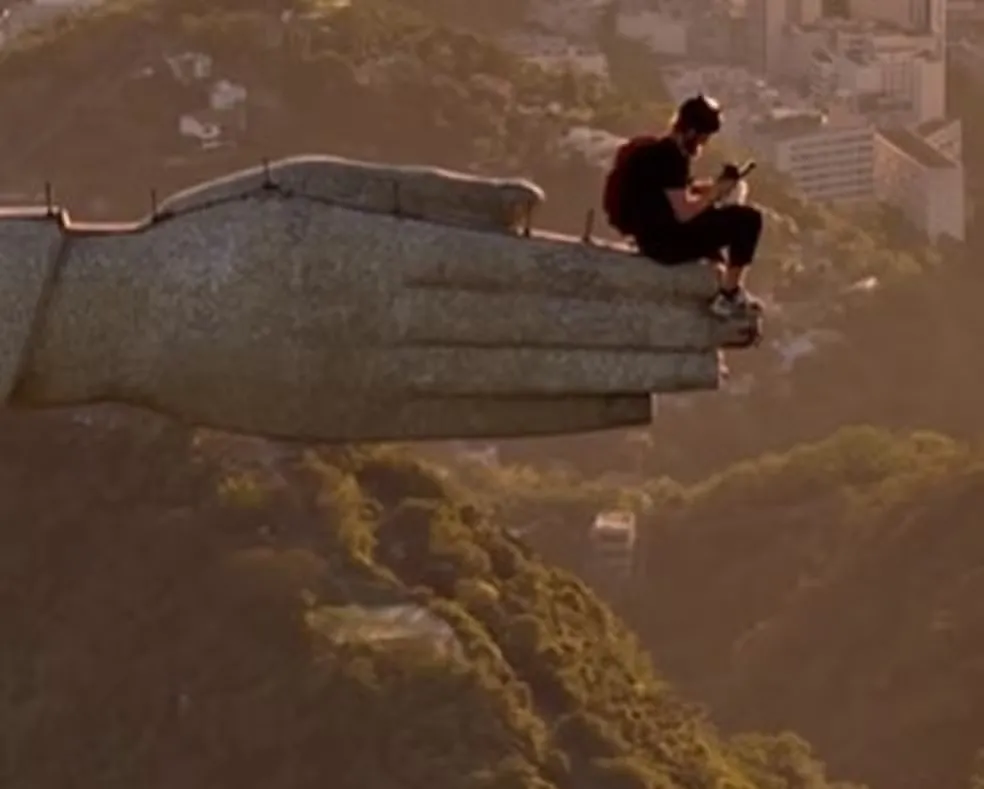 Homem escala o Cristo Redentor e salta de paraquedas da mão do monumento