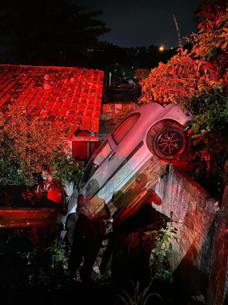 Carro bate em muro e fica pendurado no quintal de residência da região